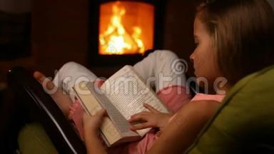 小女孩坐在火炉旁的<strong>摇椅</strong>上看书