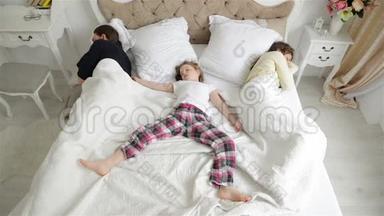 小女孩躺在父母床的主体部分，父母睡在边缘。 沉睡的肖像