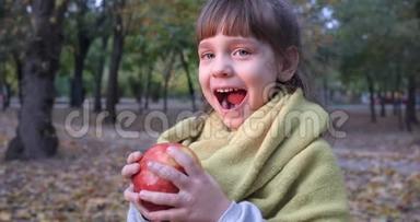 秋天，漂亮的<strong>女孩子</strong>微笑着在外面的黄色树叶的背景上咬苹果