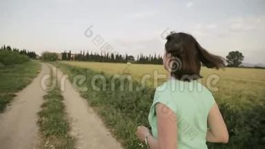 年轻的白种人妇女在西班牙<strong>农</strong>村公路上通过<strong>农</strong>村麦田享受生活和跑步