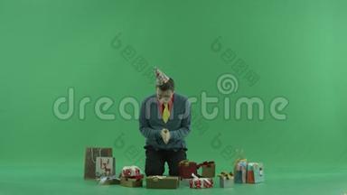 成年人带着生日礼物坐着，试着选择一个打开，绿色的关键背景