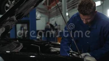 一名汽车修理工在汽车车间检查机油油位，男子肖像发动机汽车修理服务