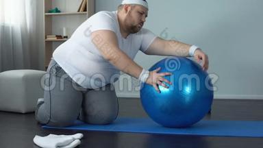疲惫的、没有动力的肥胖男人躺在健身球上，减肥健身计划