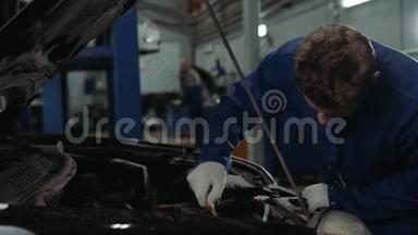 一名汽车修理工在汽车车间检查<strong>机油</strong>油位，男子肖像发动机汽车修理服务