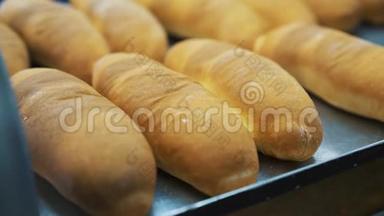面包店生产线上的面包。 面包店里烤着面包，刚出炉，里面有一个很好的面包