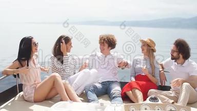 年轻的欧洲游客男女在游艇上庆祝他们的假期愉快的开始-一群朋友品尝