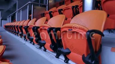 体育场竞技场座椅。 一排排橙色观众坐在体育场里。