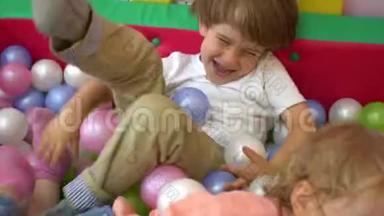 嘲笑白种人学龄前幼儿在多种颜色的球池中玩耍。 幼儿园