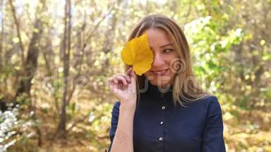 秋天色彩的森林<strong>中秋</strong>黄叶嬉戏的美丽少女画像。 4K慢动作。