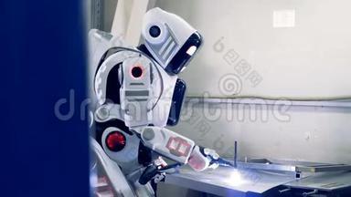 机器人焊接一个大金属片，侧视.. 工厂机器人在工作时使用焊接设备。