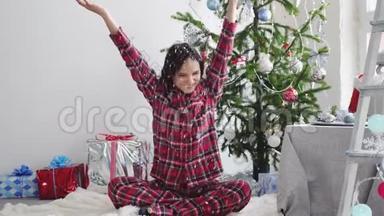 快乐的年轻漂亮女人在装饰好的工作室里的圣诞树附近扔纸屑。 慢动作。 3840x2160