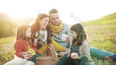 一<strong>个</strong>年轻的家庭，有<strong>两个小孩子</strong>在秋天的大自然里野餐。