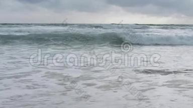 海水缓慢运动，巨浪在雨云下拍打海滩。