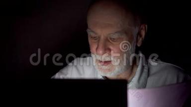疲惫的资深商人在深夜用笔记本电脑工作。 只有一张漆黑的脸