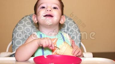 小宝宝坐在高椅后面，在胸牌里，杯子里放着冰淇淋，孩子微笑着