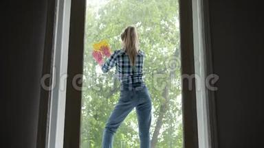 人们，家务和家务的观念-幸福的女人戴着手套，用抹布擦窗户，在家里喷清洁剂