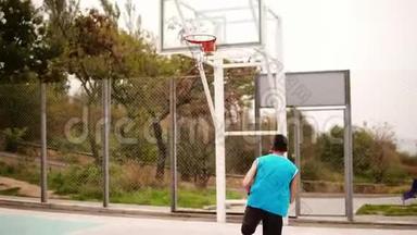 跟踪一个年轻人带着一个球跑的镜头，并成功地向篮子扔了一个球。 篮球比赛