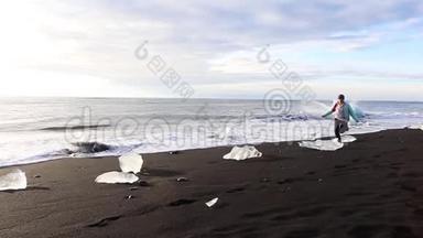 冰山和一片蓝白冰卷在海浪上.. 波浪在冰上破碎。 日出时在海滩冲浪。 冰岛。 斯隆