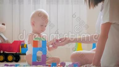<strong>妈妈</strong>和她的孩子在室内玩玩具。 <strong>在家</strong>里在地板上爬行有趣的小男孩。 <strong>妈妈</strong>和小儿子一起玩