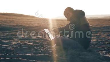 年轻的商人在日落海滩上的笔记本电脑上工作，自由<strong>职业</strong>在线旅行者自由<strong>职业</strong>者在平板电脑上工作