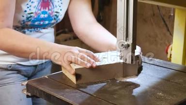 工匠正在用锯条从木头上切割一个木制玩具汽车的工件。 <strong>双手特写</strong>..