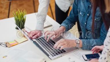 青年工人或学生讨论项目时靠近笔记本电脑