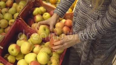 在水果蔬菜超市选择苹果的女人的手