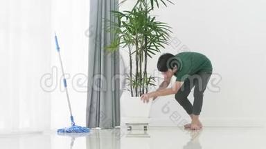 亚洲小男孩帮助家人用拖把打<strong>扫房子</strong>。
