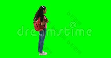 <strong>背着书包</strong>站在绿色背景下的女孩