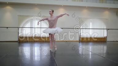 芭蕾舞演员穿着白色芭蕾舞裙在舞蹈室或健身房练习。 女人在课堂上跳古典舞。 孤独