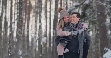 这对幸福的夫妇正在外面玩冬季游戏，在山上享受阳光和温暖的冬季天气。强壮的男孩是