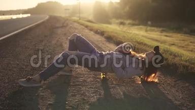 女孩嬉皮士躺在路边的滑板上，听<strong>音乐</strong>复古<strong>播放器</strong>。 红发肖像