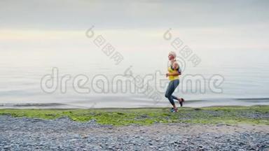 一个年轻的女人沿着海边或<strong>湖边</strong>慢跑，<strong>秋天</strong>，早晨