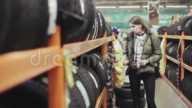 女人为她的车选择新轮胎。 从夏天到冬天在车上换轮胎。 <strong>书店</strong>和<strong>书店</strong>
