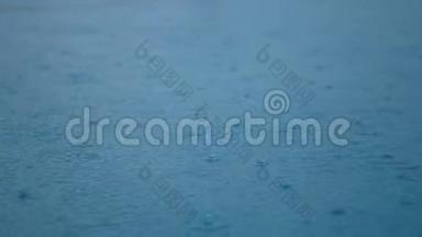 4K. 特写镜头雨滴在<strong>清</strong>澈的蓝色<strong>水面</strong>上，天空和云彩反射在<strong>水面</strong>上。 雨，细雨，细雨
