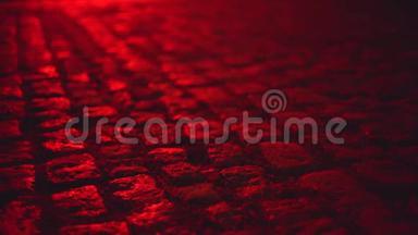 夜晚，红色的鹅卵石铺砌的街道照亮了潮湿的环境