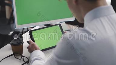 年轻人使用绿色屏幕的电脑和平板电脑。 4K