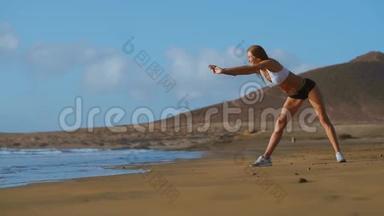 女人伸展腿和腿筋做站立前弯曲瑜伽伸展姿势在海滩上。 健身妇女放松<strong>身心</strong>