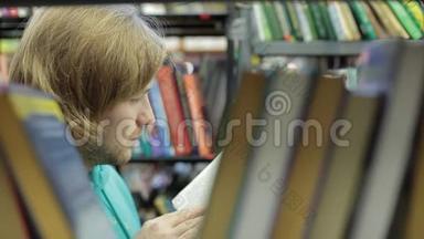 一个年轻人在图书馆里选一本书。 许多书，他在书丛之间的走廊里