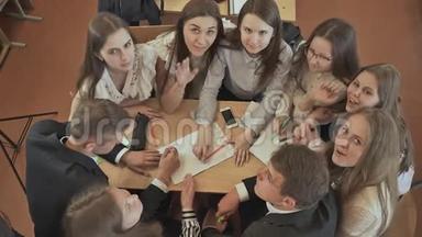 同学们<strong>围坐</strong>在桌子旁，讨论学校的任务，然后挥手。俄罗斯学校。