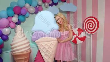 女孩拿着巨大的冰淇淋在彩色工作室。