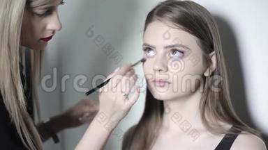 化妆师使用矫正器。年轻女孩化妆粉底