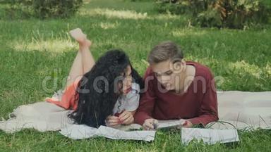 年轻的女孩和男孩准备在格子花呢的夏季公园参加考试