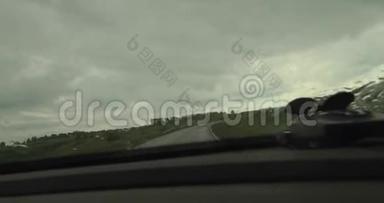 在雨中驾驶汽车，雨滴在挡风玻璃上。 4K