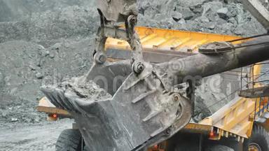 挖土机在采石场用矿石装载翻斗车。 采矿业。