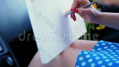 特写镜头。 在一个女艺术家的膝盖上是一张画布，上面有一支<strong>铅笔素描</strong>的蒲公英花束。 她坐在车里