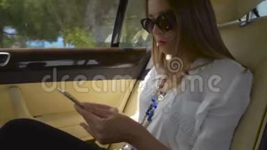 年轻漂亮的女商人<strong>坐出租车</strong>，在智能手机上上网