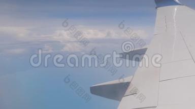 在机翼飞行时透过窗户看飞机，有一个美丽的蓝天。
