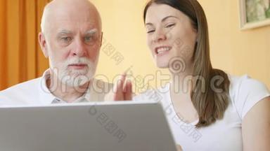老年父女使用笔记本电脑。十几岁的孙女教爷爷如何使用笔记本电脑