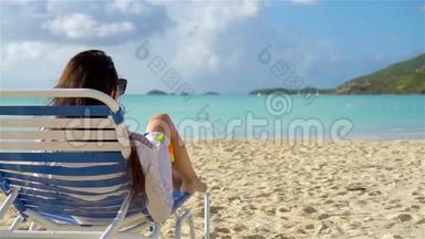 暑假的时候，躺在沙滩上晒太阳的女人放松和享受。慢动作